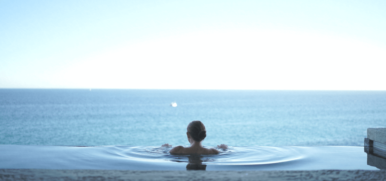 温泉で海を見る留学生女性