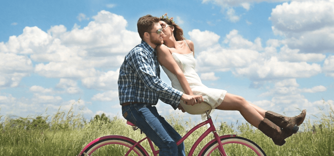 外国のカップルが二人で自転車に乗る様子