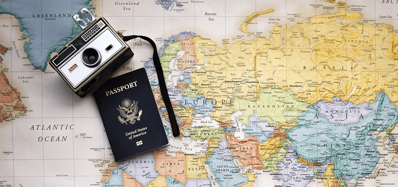 世界地図の上で広げられたパスポート